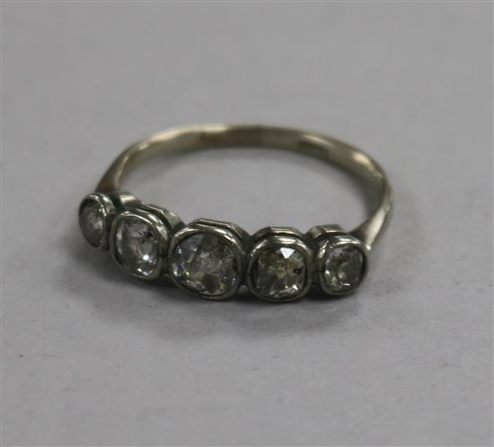 An early 20th century 18ct gold and graduated collet set five stone diamond ring, size O.